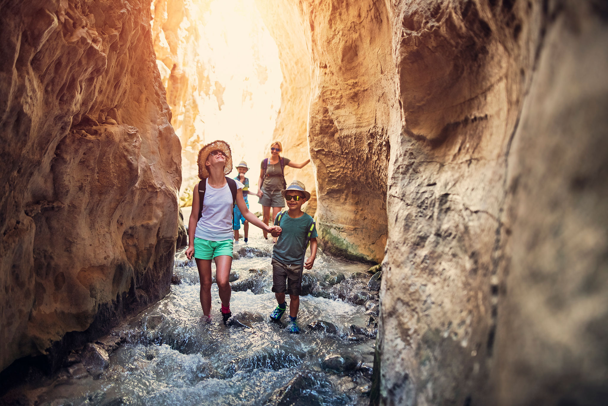 A mother and kids hike through the Rio Chillar flowing through a narrow canyon in Andalusia, Spain.
