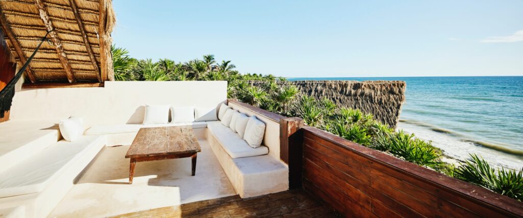 Wide shot of sitting area on deck of luxury suite at tropical resort